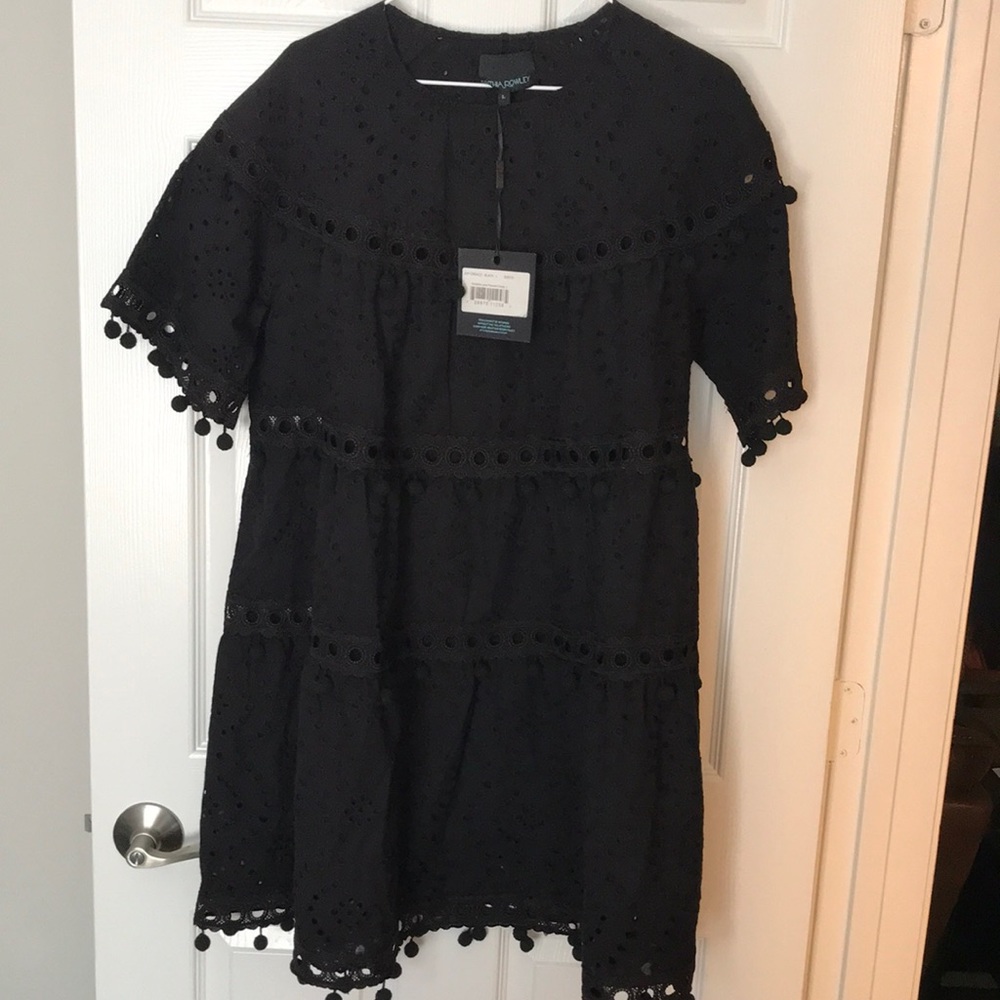 Cotton eyelet swing dress with open lattice trim with Pom Pom details.